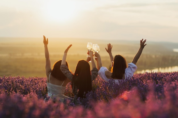 vriendinnen rammelen glazen met witte wijn en samen tijd doorbrengen op picknick