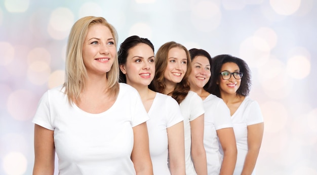 Foto vriendschap, divers, lichaam positief en mensen concept - groep gelukkige vrouwen van verschillende grootte in witte t-shirts over vakantie lichten achtergrond