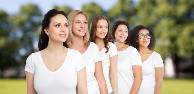 Foto vriendschap, divers, lichaamspositief en mensenconcept - groep gelukkige vrouwen van verschillende grootte in witte t-shirts over zomerparkachtergrond