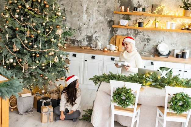 Vriendschap en liefde van moeder en dochter. Familie waarden. Voorbereiden om Kerstmis te vieren. Kerstboom decoratie. Een goede band opbouwen tussen moeder en dochter.