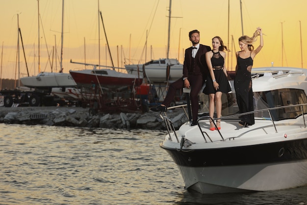 Vriendschap en vakantie. Feest op het jacht. Groep jonge mensen op het dek dat de zee vaart.