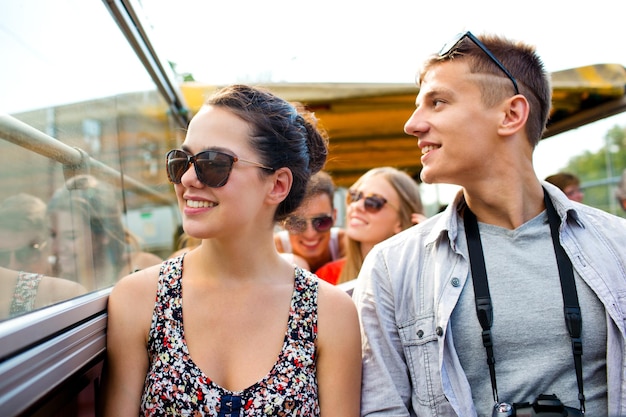 vriendschap, reizen, vakantie, zomer en mensen concept - glimlachend paar met camera reizen met de tourbus
