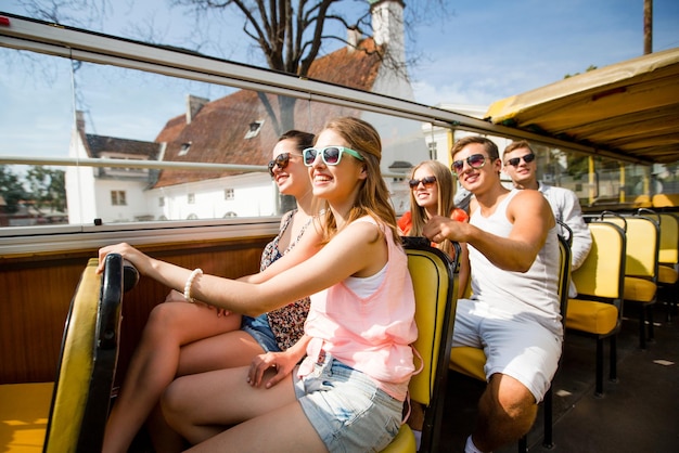 vriendschap, reizen, vakantie, zomer en mensenconcept - groep glimlachende vrienden die met de tourbus reizen