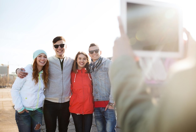 vriendschap, technologie en mensen concept - groep gelukkige tienervrienden in zonnebril met tablet pc-computer buitenshuis fotograferen