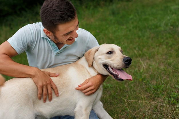 Vriendschap van mens en hond. Gelukkig jonge man speelt met zijn vriend