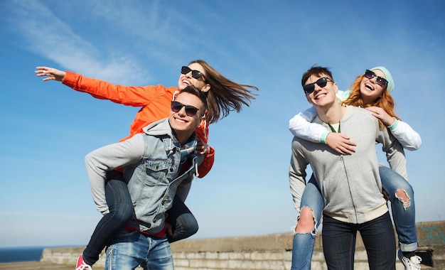 vriendschap, vrije tijd en mensen concept - groep gelukkige tienervrienden in zonnebril plezier buitenshuis