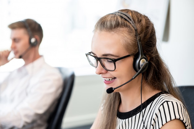 Vriendschappelijke vrouw die in call centrebureau werkt