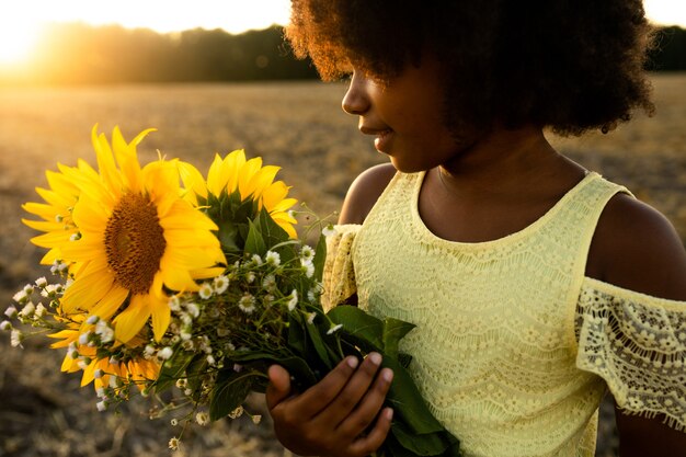 Vrij afro-amerikaans meisje in een zonnebloemenveld met plezier