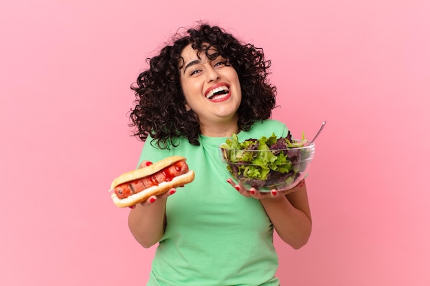 Vrij Arabische vrouw met een salade en een hotdog. dieet concept