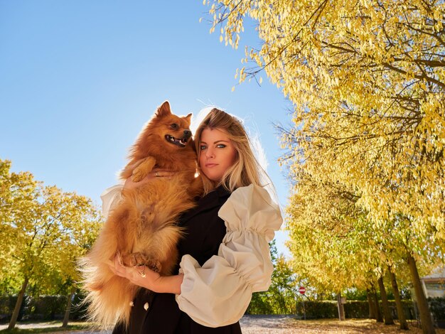 Vrij blond meisje speelt met Pommerse hond