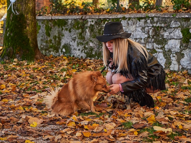 Vrij blond meisje speelt met Pommerse hond