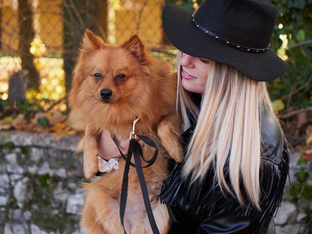 Vrij blond meisje speelt met Pommerse hond