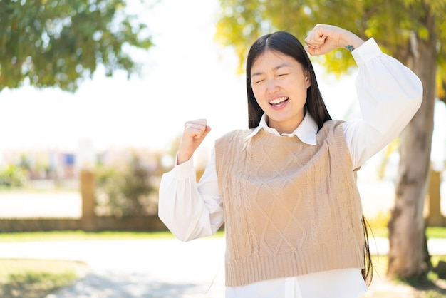 Vrij Chinese vrouw die in openlucht een overwinning viert