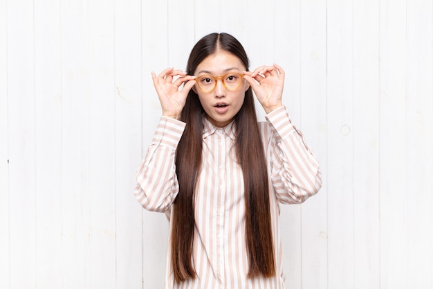 vrij chinese vrouw tegen witte muur