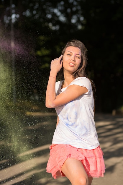 Vrij donkerbruine aziatische vrouw die met droge groene verf op Holi-kleurenfestival speelt