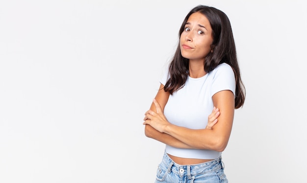 Vrij dunne Spaanse vrouw die haar schouders ophaalt, zich verward en onzeker voelt