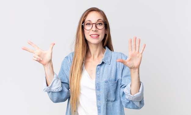 Vrij dunne vrouw die lacht en er vriendelijk uitziet, nummer acht of achtste toont met de hand naar voren, aftellend