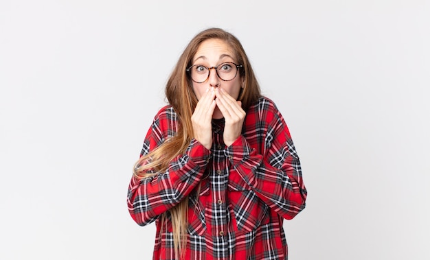 Vrij dunne vrouw die zich bezorgd, overstuur en bang voelt, haar mond bedekt met handen, er angstig uitziet en het verprutst heeft