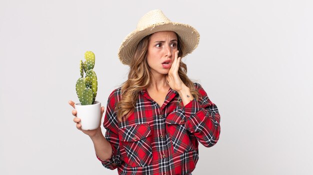 Vrij dunne vrouw die zich gelukkig, opgewonden en verrast voelt met een cactus. boer concept