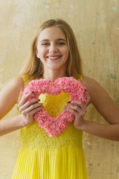 Foto vrij gelukkig meisje met roze rieten hart voor valentijnsdag