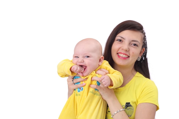 Vrij gelukkige jonge moeder met de schattige kleine baby gekleed in gele kleding