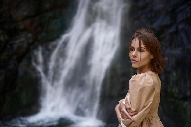 Vrij jong meisje met bruin haar tegen de achtergrond van waterval