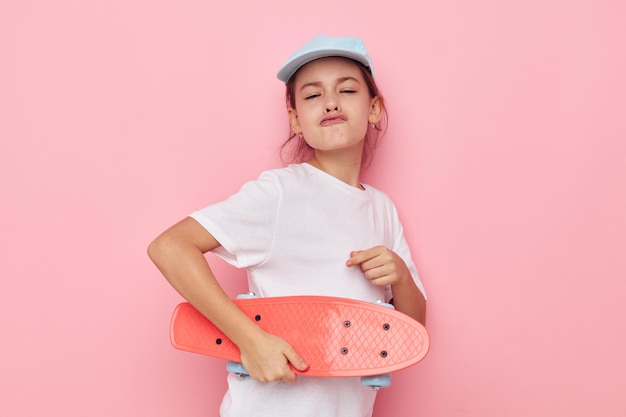 Vrij jong meisje met een skateboard in de hand ongewijzigde kinderjaren