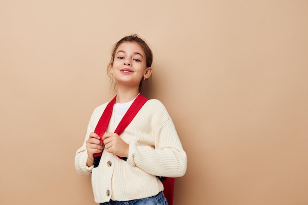 Vrij jong meisje schoolmeisje met rode rugzak poseren levensstijl ongewijzigd?