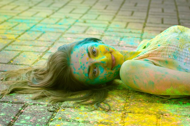 Vrij jong model ligt op de stoep met poeder Holi