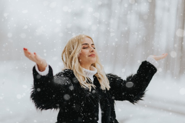 Vrij jonge blonde vrouw bij sneeuw de winterdag