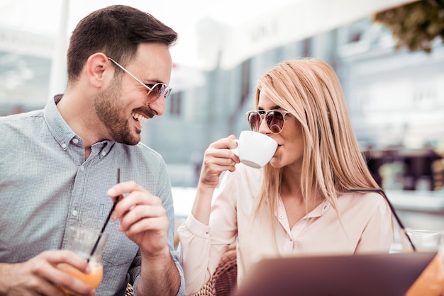 Vrij jonge onderneemster die koffie drinkt tijdens de vergadering