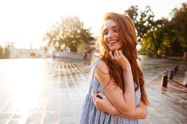 Vrij jonge roodharigevrouw met het lange haar lachen