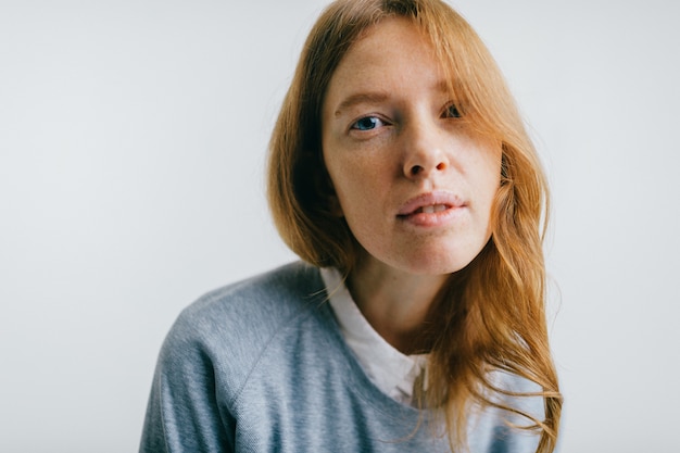 Vrij jonge sproetenvrouw met het rode lange portret van de haarstudio