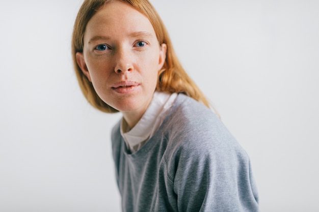 Vrij jonge sproetenvrouw met het rode lange portret van de haarstudio