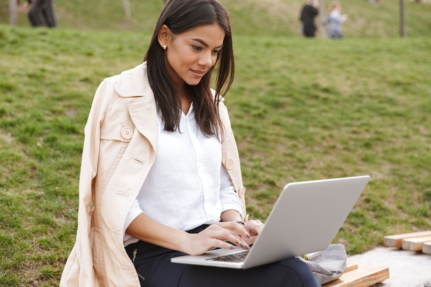 Vrij jonge vrouw die laptop computer met behulp van