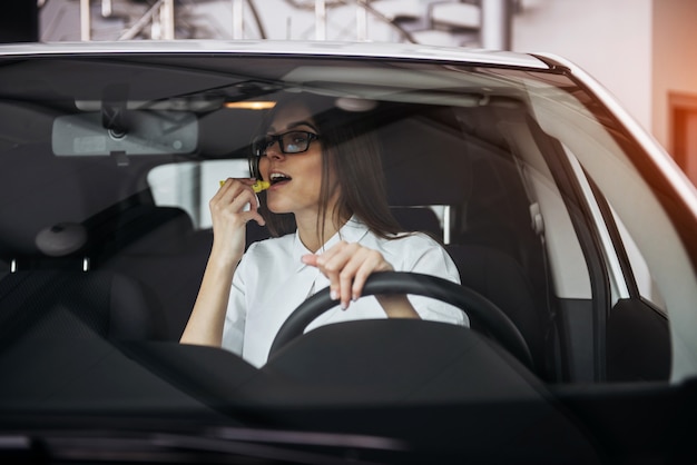 Vrij jonge vrouw die nieuwe auto drijft.