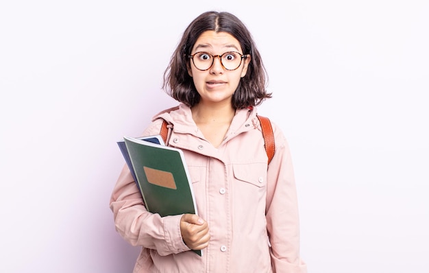 Vrij jonge vrouw die verward en verward kijkt. student met boeken concept