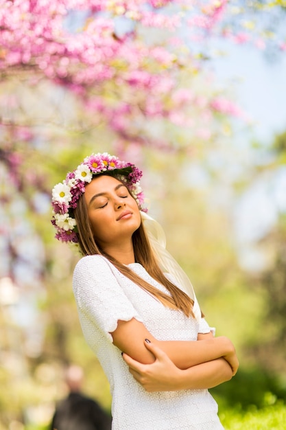 Vrij jonge vrouw met bloemen in haar haar op zonnige de lentedag