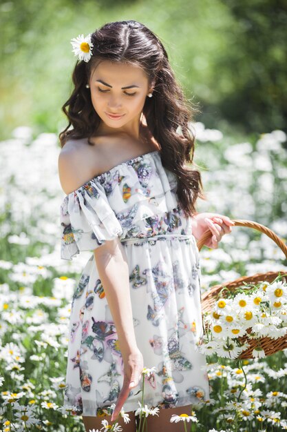 Vrij jonge vrouw op het gebied van kamille. Mooi meisje met bloemen