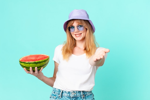 Vrij rode hoofdvrouw en die een watermeloen houden. zomer concept