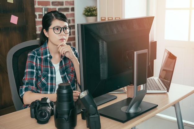 vrij rustige vrouwelijke fotograaf vrouw die aan een bureau werkt en zakelijke foto's bewerkt, het beste voor online aandelenbedrijf.