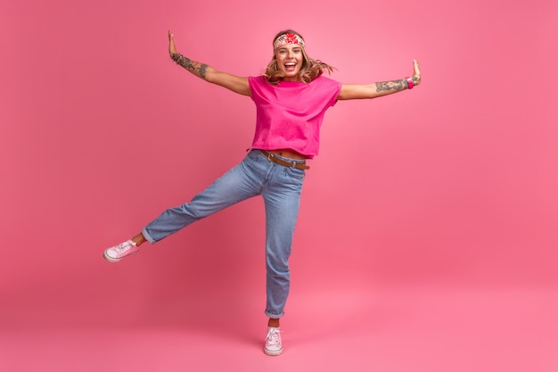 Vrij schattige lachende vrouw in roze shirt boho hippie stijl accessoires glimlachend emotioneel plezier poseren op roze geïsoleerd