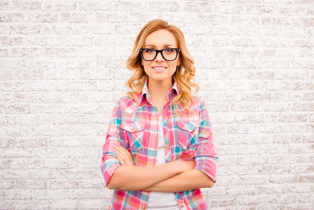 Vrij slimme jonge vrouw in glases met gekruiste handen