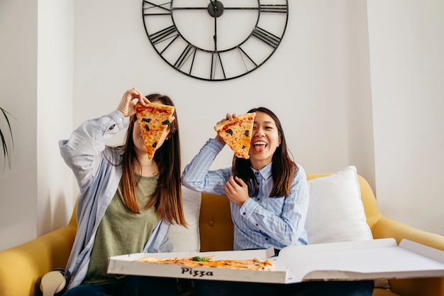 Foto vrij toevallige meisjes die pret hebben die van pizza geniet