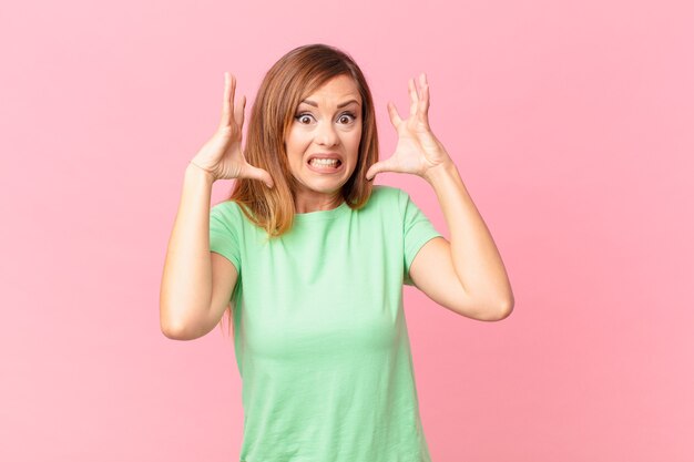 Vrij volwassen vrouw schreeuwen met handen omhoog in de lucht