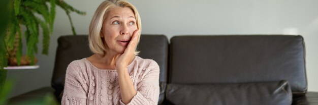 Vrij volwassen vrouw zittend op de bank