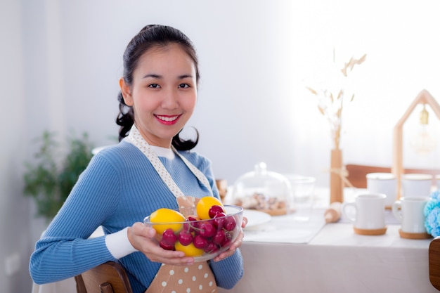 Vrij vrouwelijke holdingskom met een glimlach in keuken