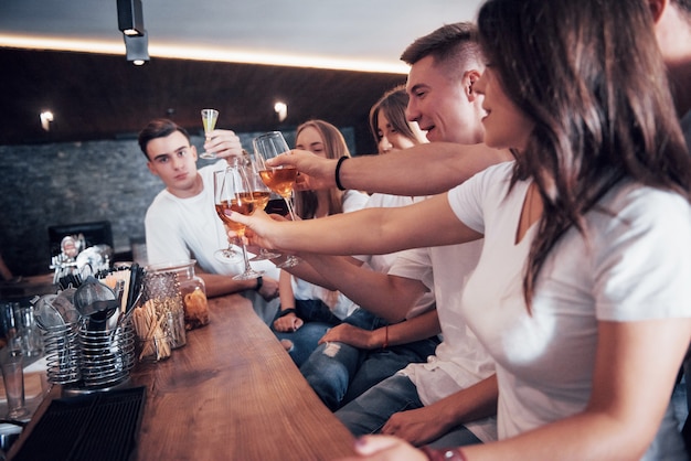 Vrije tijd en communicatieconcept. Groep gelukkig lachende vrienden genieten van drankjes en praten in de bar of pub