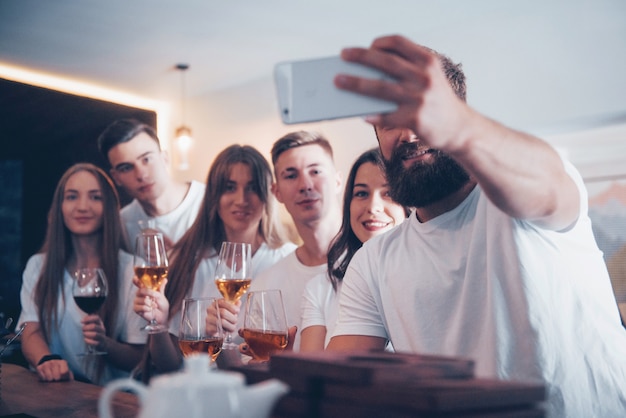 Vrije tijd en communicatieconcept. Groep gelukkig lachende vrienden genieten van drankjes en praten in de bar of pub