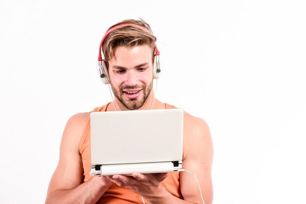 Vrije tijd en plezier man met koptelefoon en laptop studentenleven online entertainment onderwijsmogelijkheden gadget maakt het leven veel gemakkelijker draagbare gadget man gebruikt moderne technologieën gadget